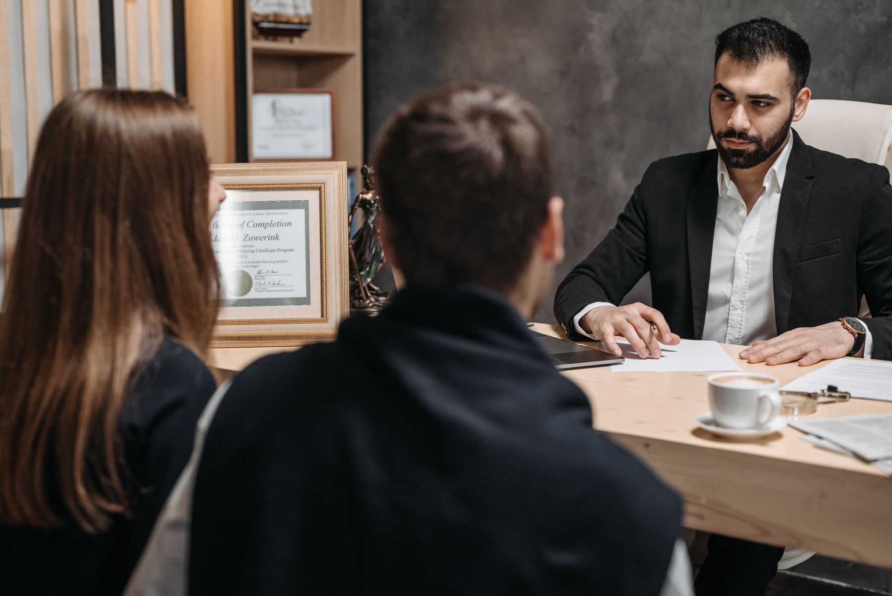 Abogado asesorando a una pareja de clientes durante una consulta legal